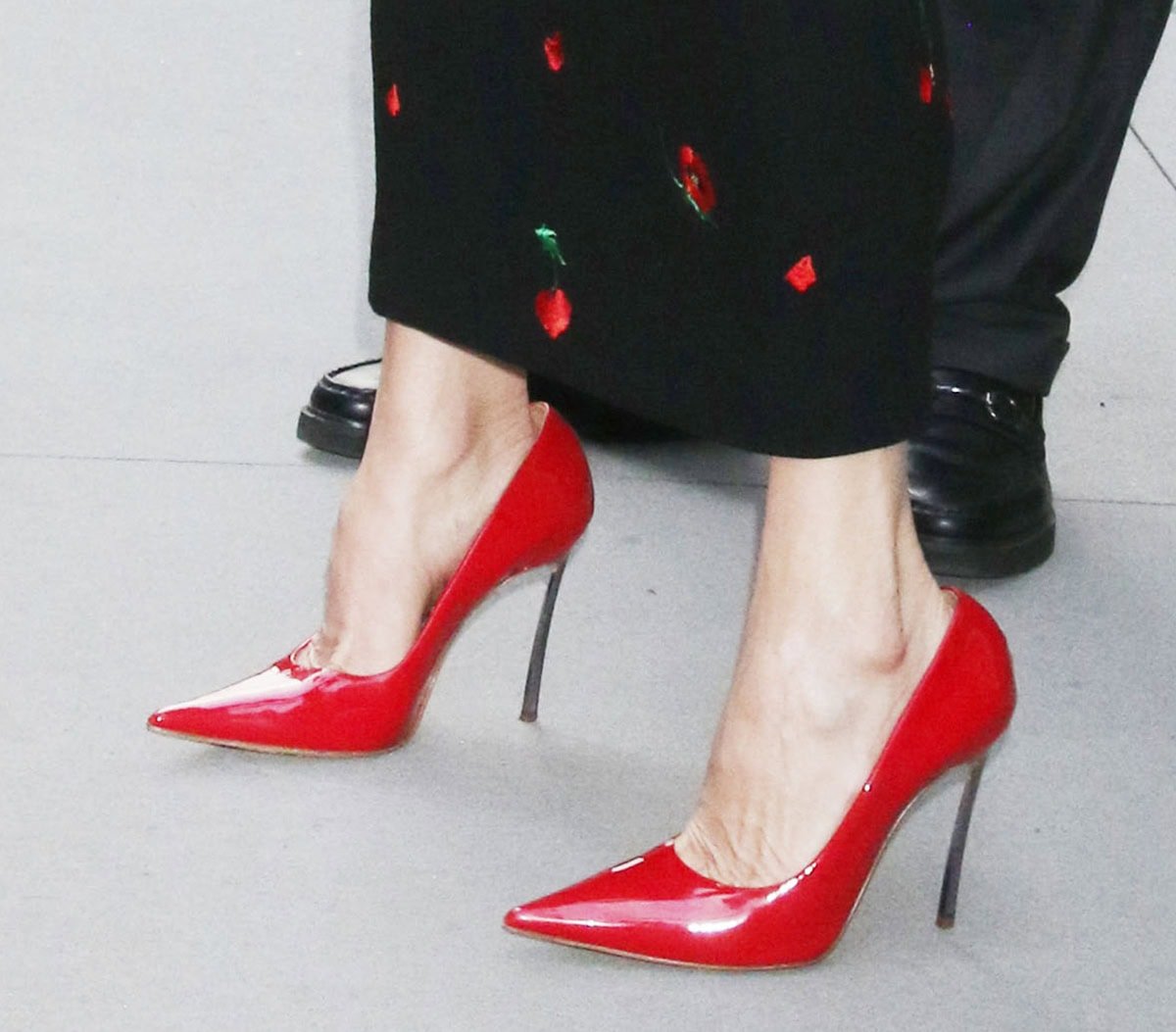 Catherine Zeta-Jones completes her chic Morticia Addams ensemble with shiny red Casadei Superblade pumps