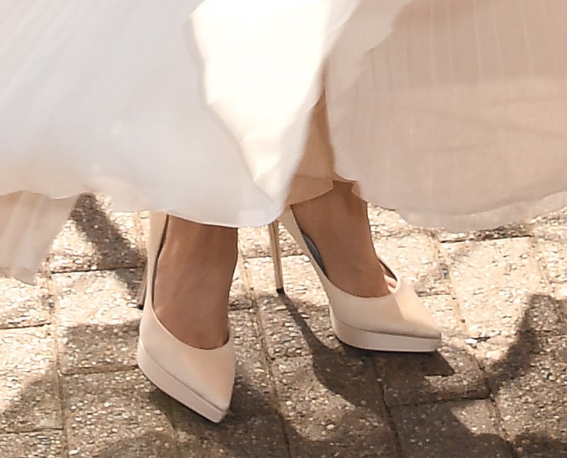 Sofia Carson creates an elegant monochromatic ensemble by pairing her chiffon gown with ivory satin platform pumps with pointed toes and stiletto heels