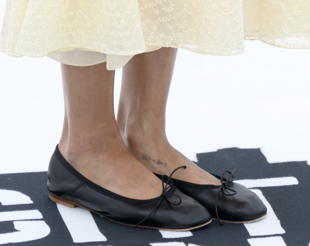 Zoe Kravitz adds a modern edge to her classic, feminine dress with contrasting black sunglasses and black Mansur Gavriel Dream ballet flats