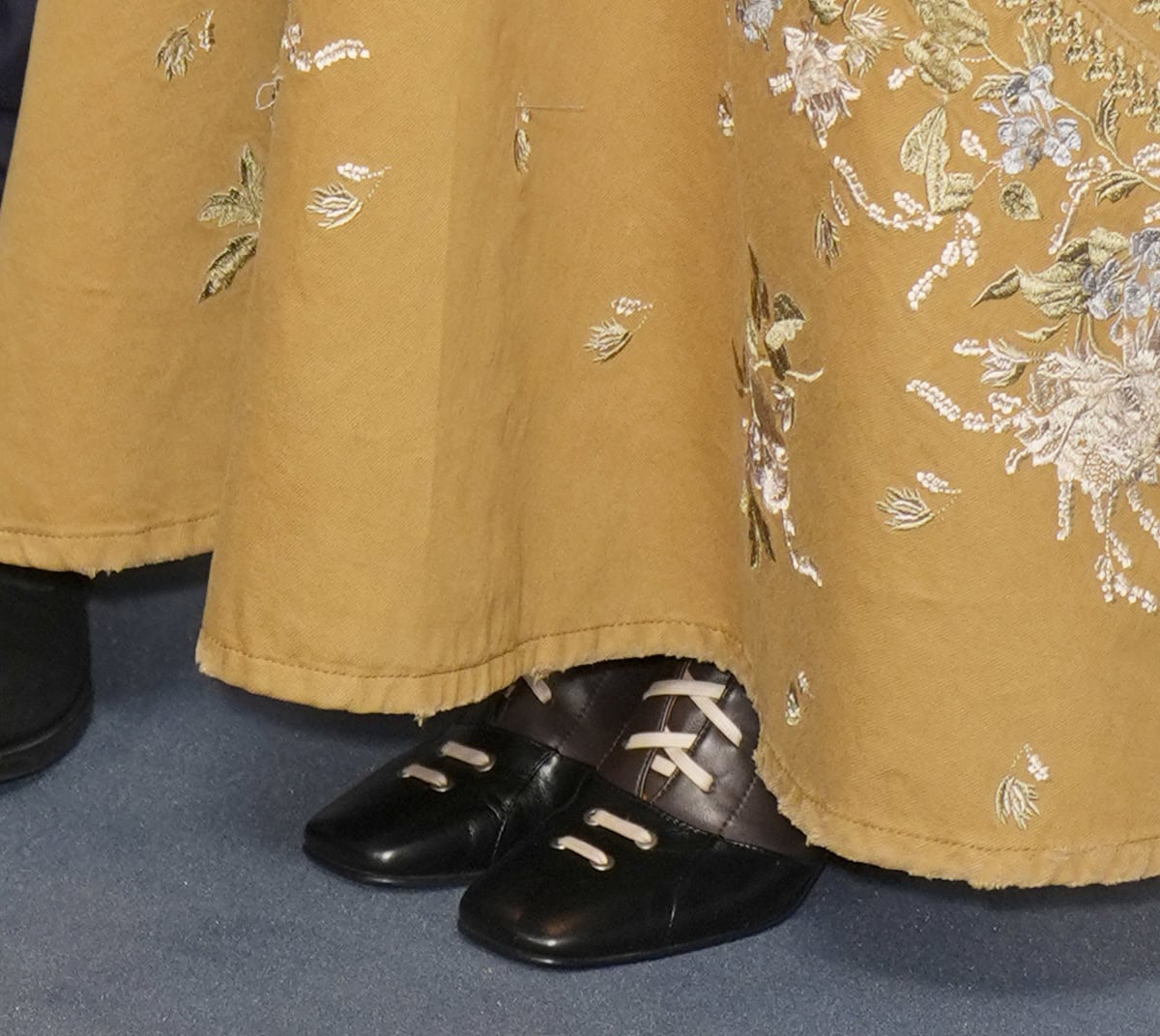 Keira Knightley grounds her embroidered Erdem gown with two-tone “Isadora” lace-up equestrian boots by Lili Curia, adding a bold Victorian-meets-modern edge to the look