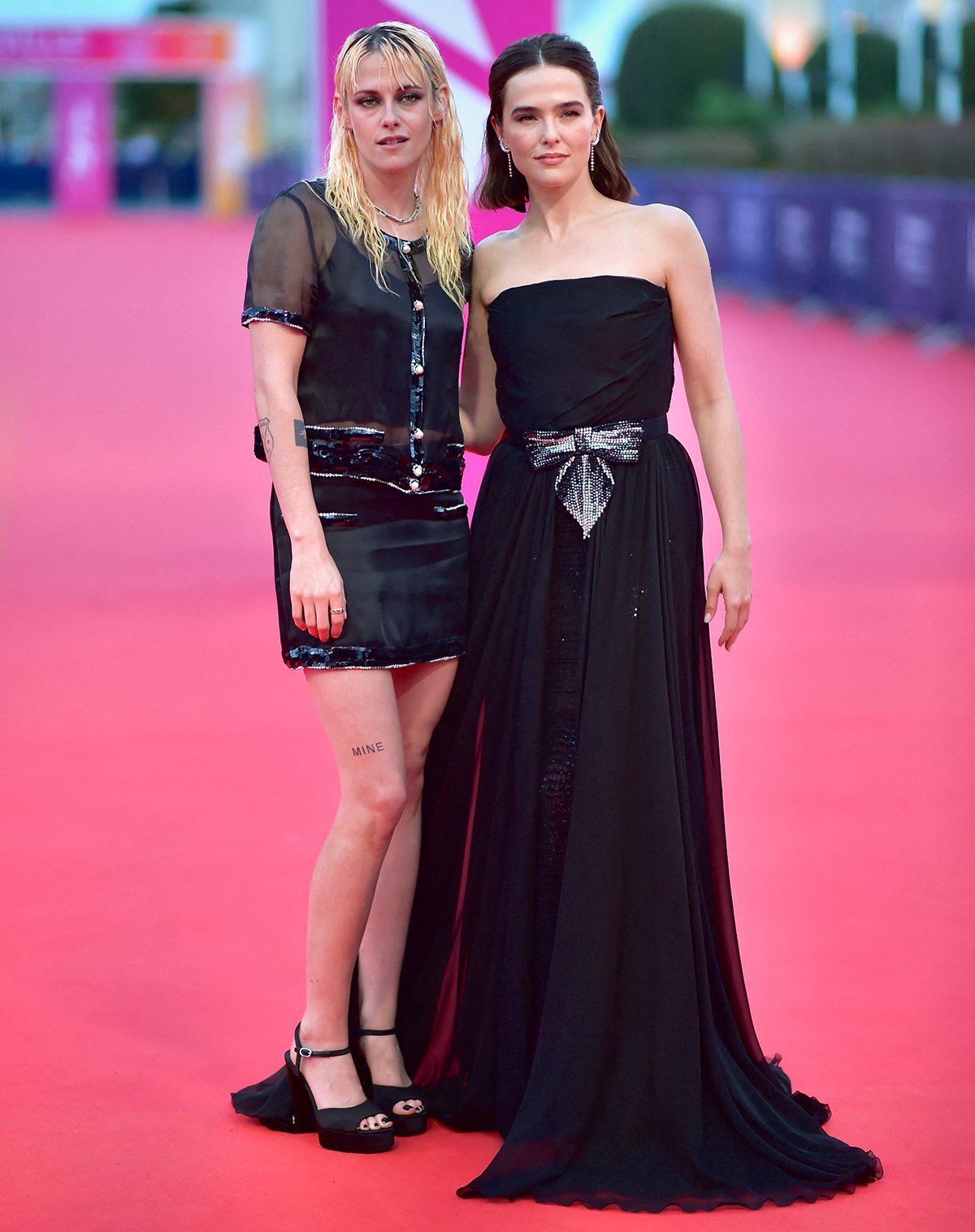 Kristen Stewart, with Nouvelle Vague star Zoey Deutch, redefines Chanel in a sheer black blouse and mini skirt combination featuring silver-and-black sequin trims, giving the look a rebellious twist
