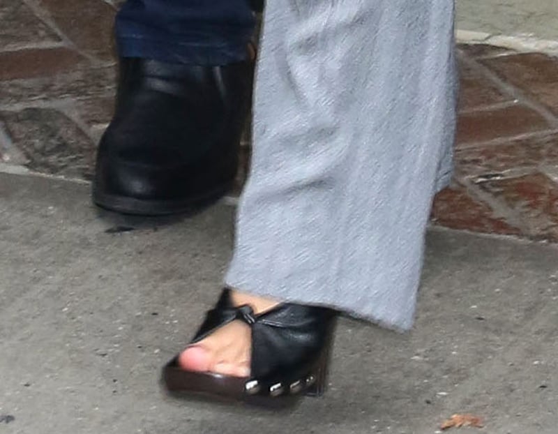 Margot Robbie completes her modern monochromatic business look with chunky wooden clogs by Phoebe Philo