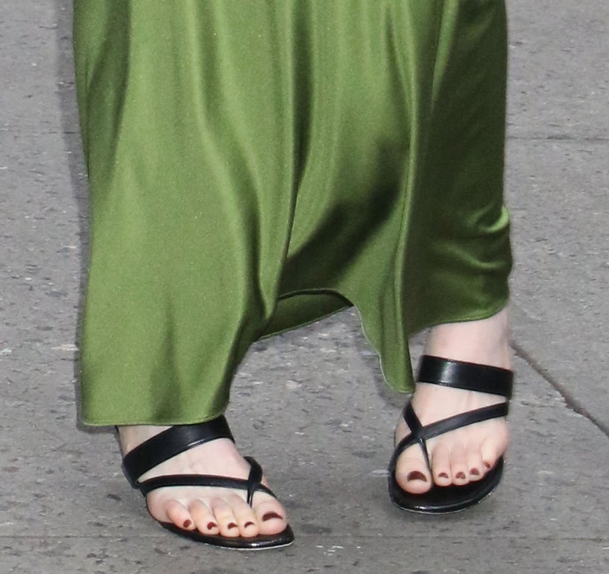 Emma Stone pairs her green blouse and skirt combo with strappy black Manolo Blahnik "Susa" mules featuring crossover straps and fluted kitten heels