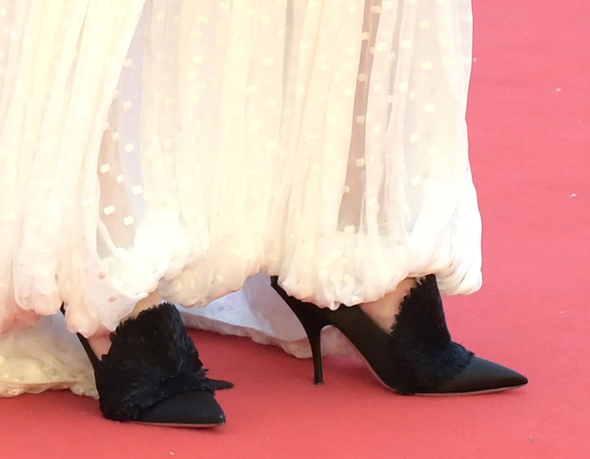 Jennifer Lawrence completes her whimsical look with black Dior pumps featuring a high vamp with a feather-like accent and a high back