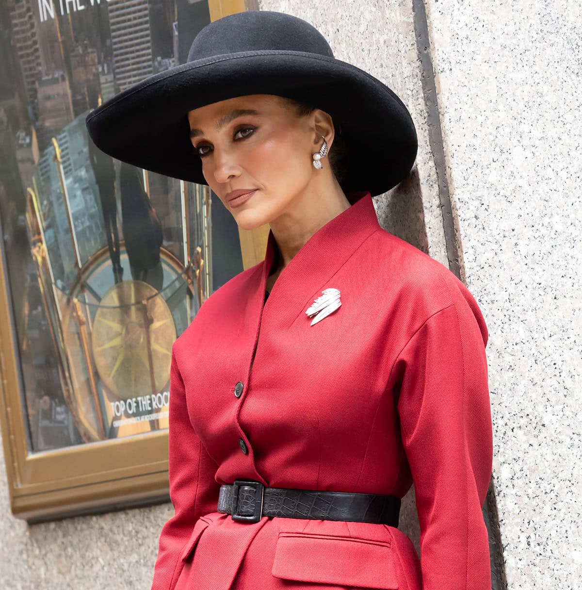 Jennifer Lopez looks unrecognizable with her hair tucked underneath a wide-brimmed black hat and her features highlighted with warm, rosy makeup