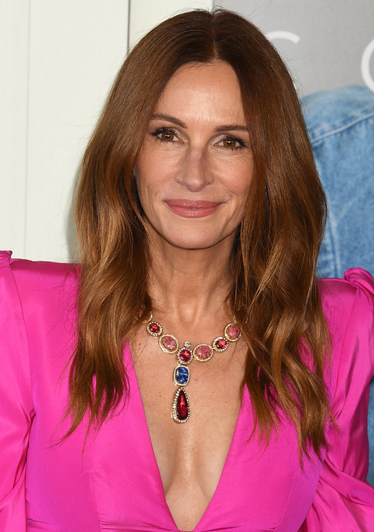 Julia Roberts styles her plunging hot pink silk faille dress with a statement Sabyasachi necklace featuring a mix of sapphire, tourmalines, thulite, labradorite, and brilliant-cut diamonds