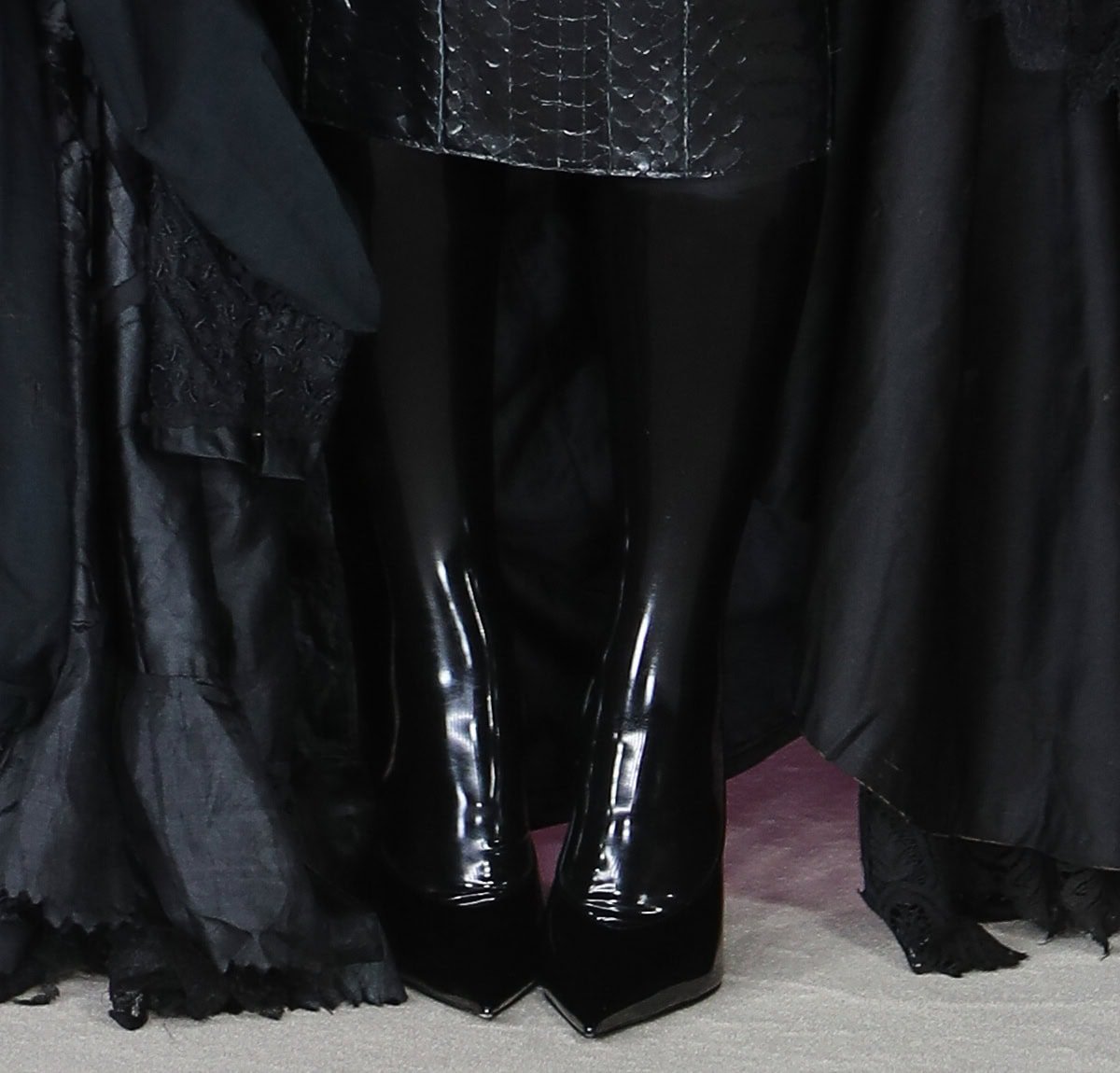 Kim Kardashian pairs her gothic dress with shiny black patent pointed-toe boots by Amina Muaddi