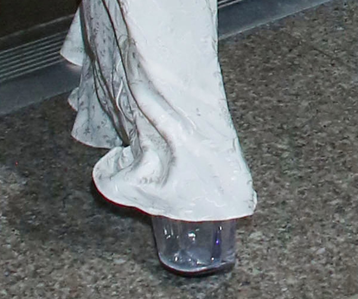 Kim Kardashian adds a futuristic twist to her vintage white gown with clear PVC platform sandals featuring thick lucite heels and see-through straps that subtly elongate her silhouette while maintaining her minimalist aesthetic