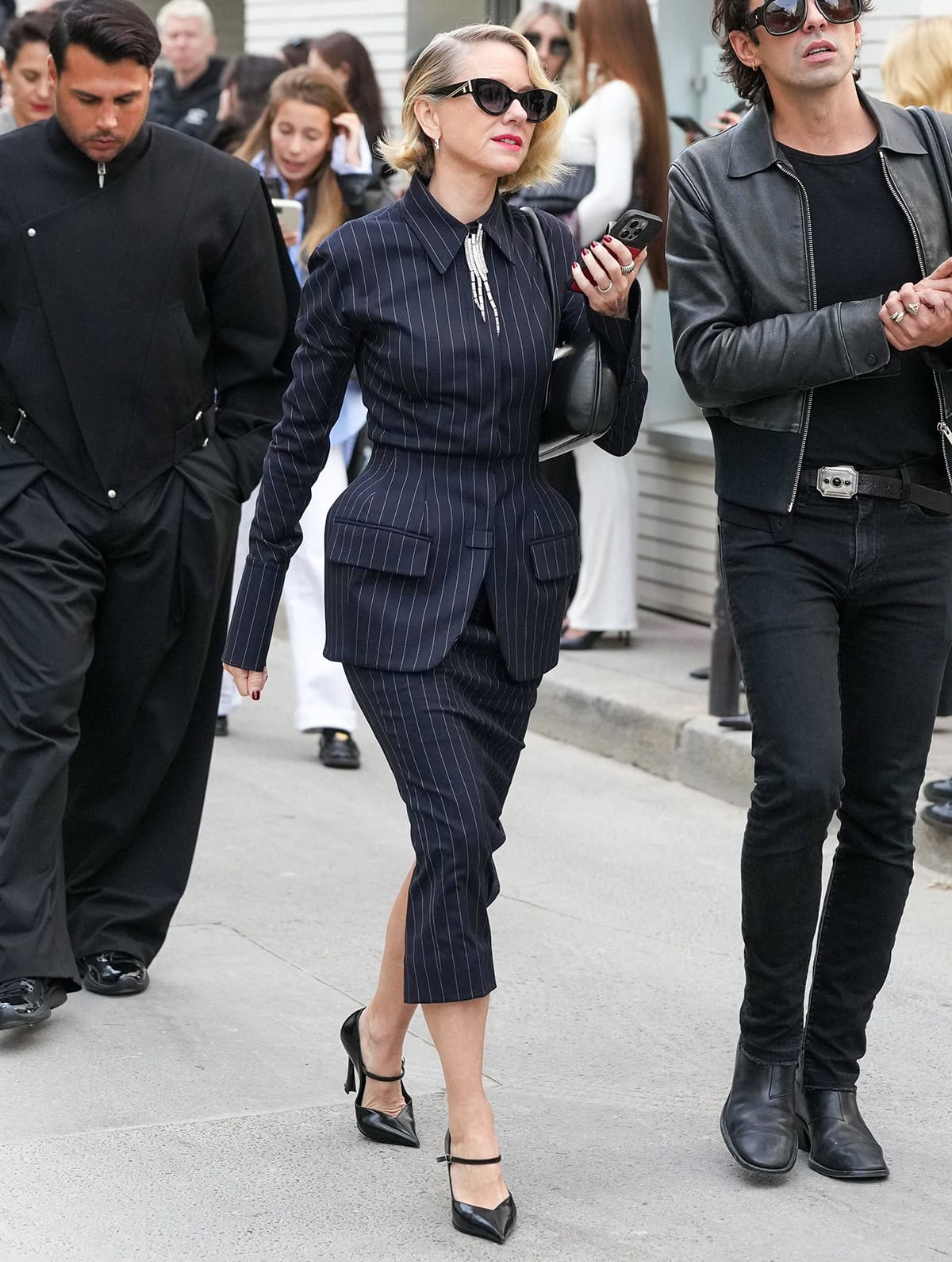 Naomi Watts brings modern edge with a vintage twist to the Mugler show, wearing a navy pinstriped blazer with a sculptural flared hip and a matching pencil skirt