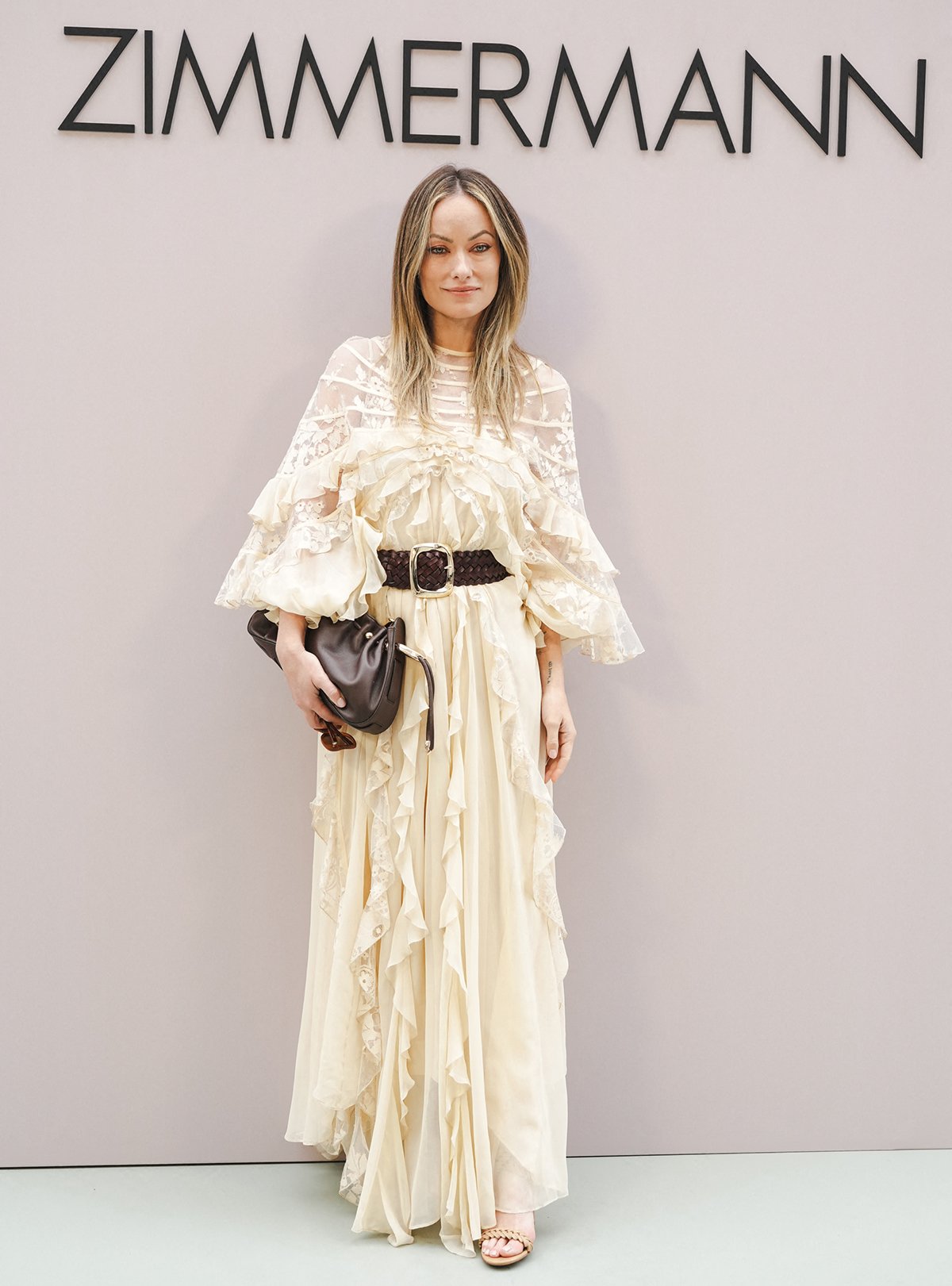 Olivia Wilde showcases her signature bohemian style in an ivory ruffle lace dress by Zimmermann at the Australian label's Paris Fashion Week Womenswear Spring Summer 2026 presentation