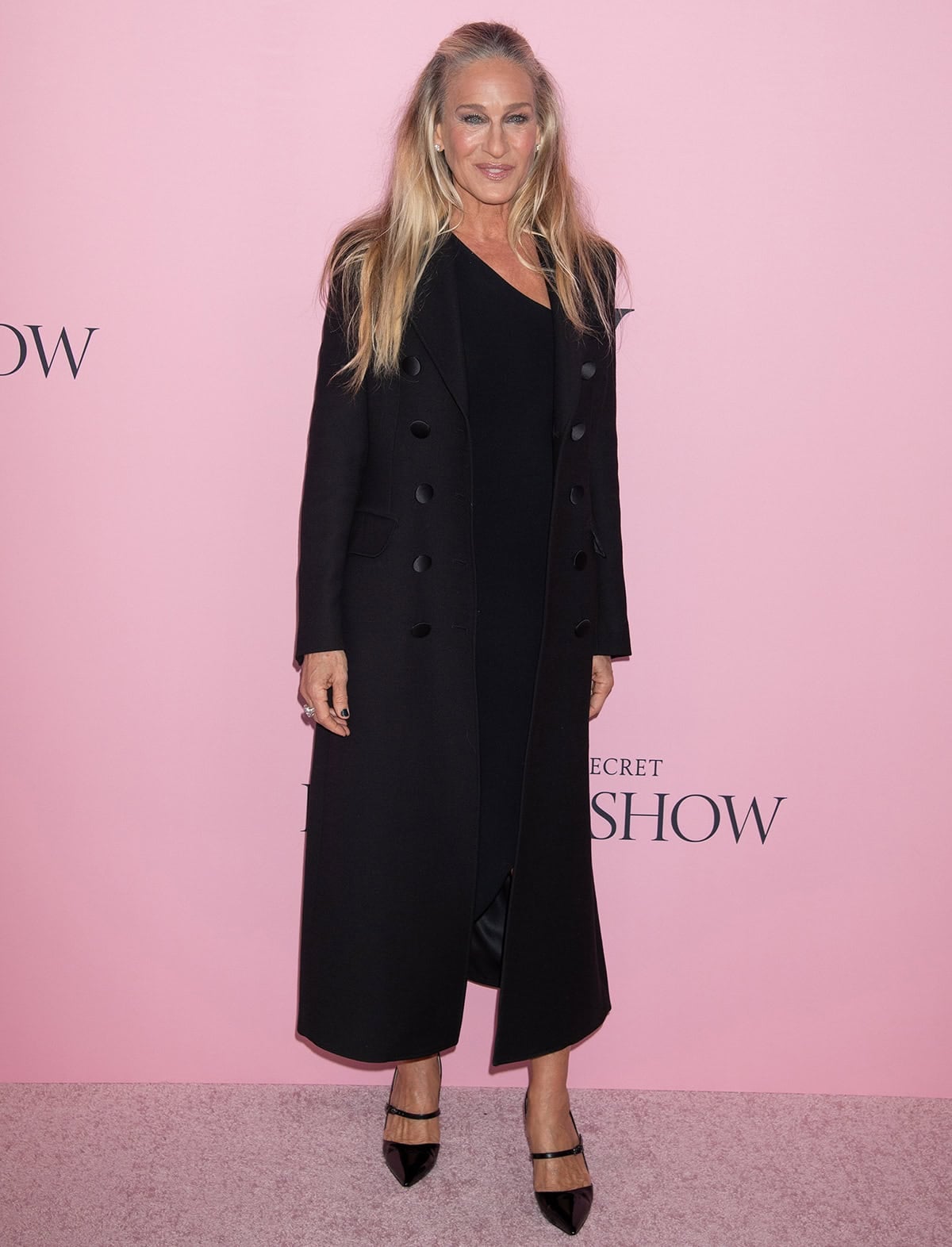 Sarah Jessica Parker pairs her classic Mary Janes with a timeless LBD by Alexander Wang featuring an asymmetrical one-shoulder neckline and a long black coat