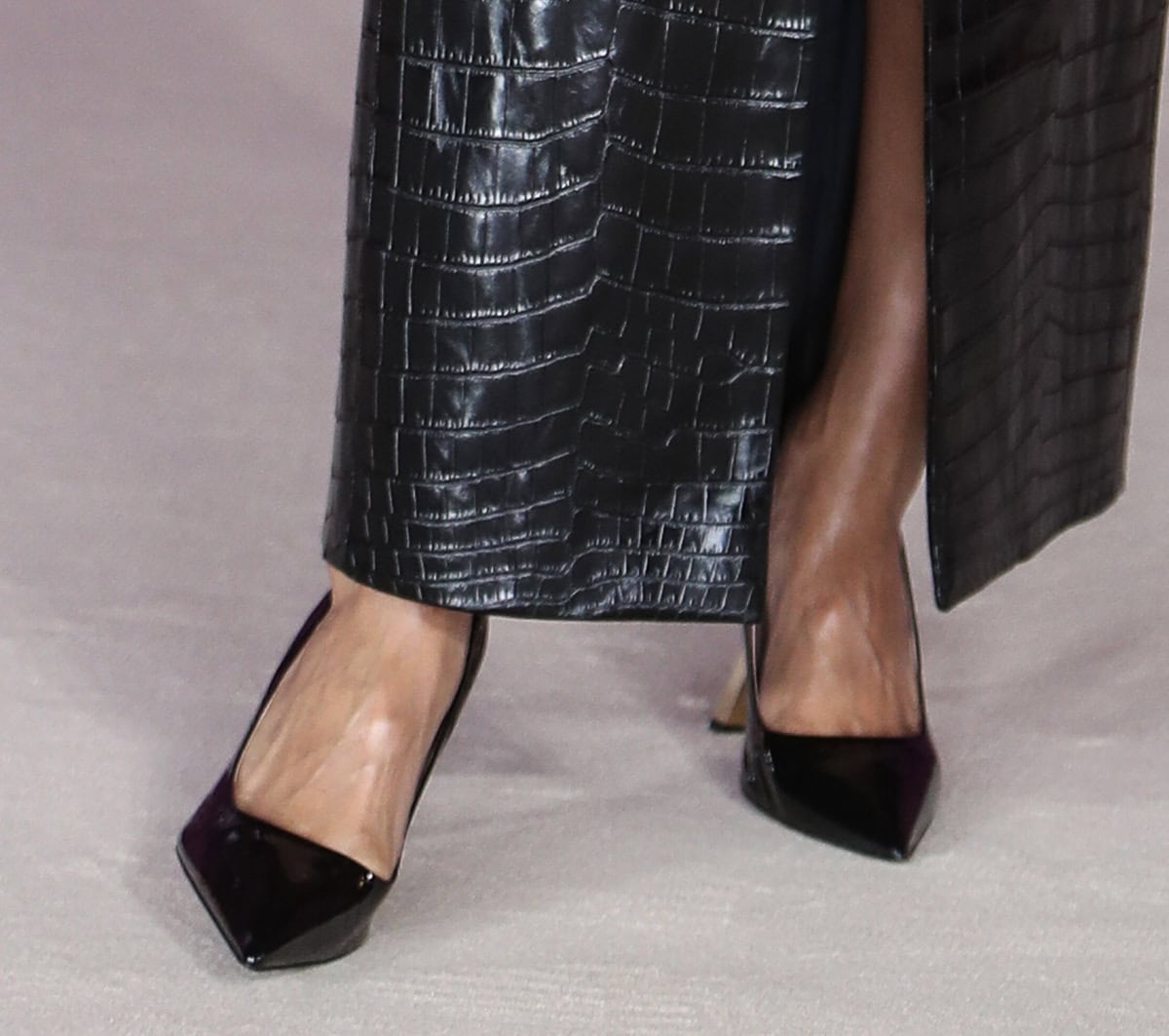 Teyana Taylor keeps her footwear simple, wearing just a pair of black patent pointy pumps, to allow her dress to take center stage