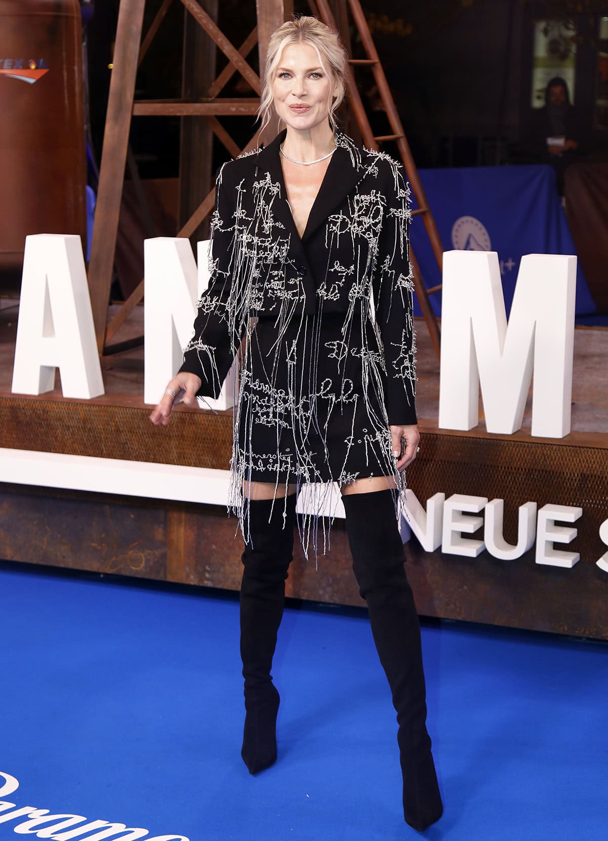 Ali Larter opts for a modern edge by wearing a black cropped blazer and a matching mini skirt embroidered with silver beads that form scattered scripts and scribbles at the Landman Season 2 Berlin premiere