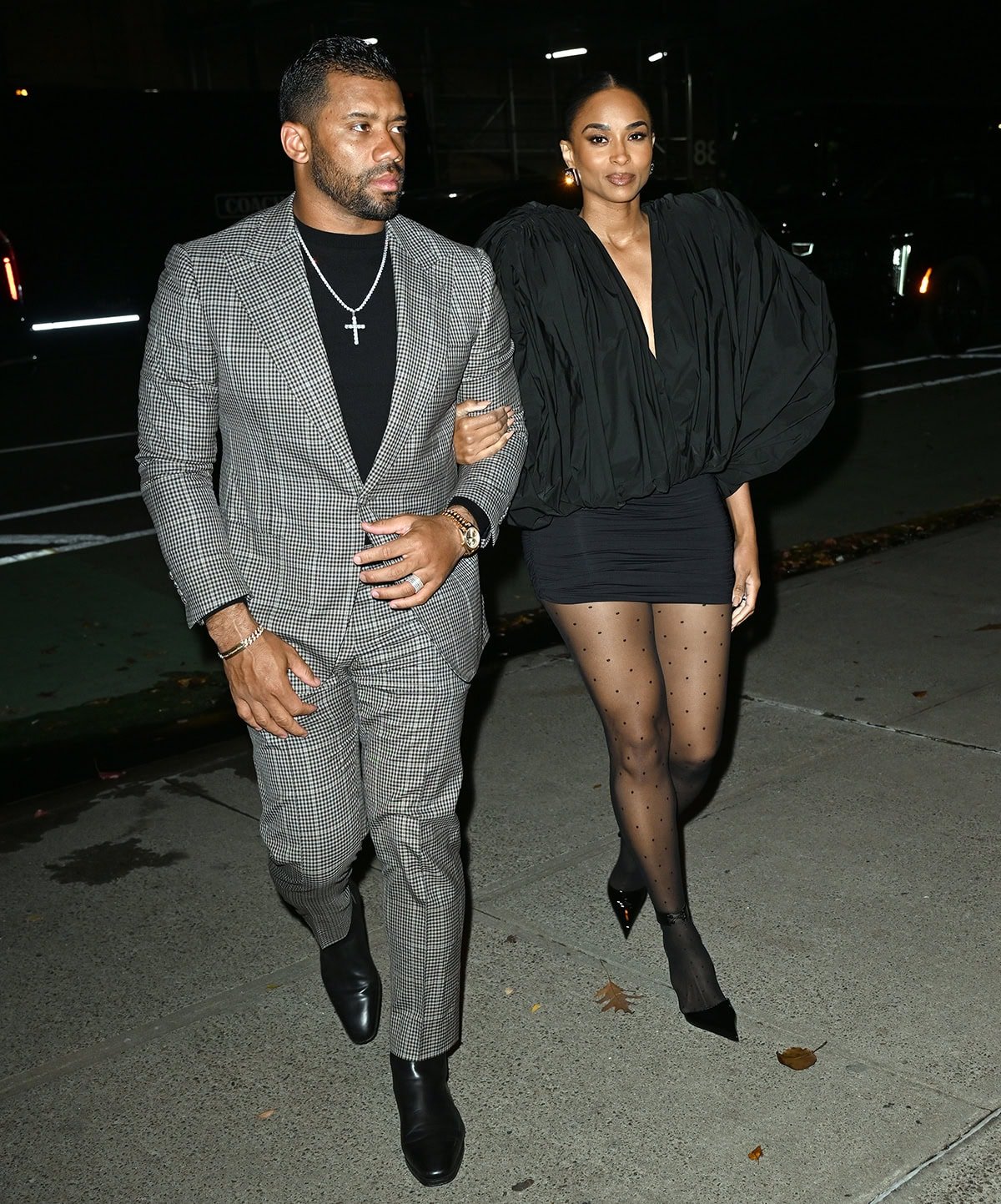 Ciara, with her husband Russell Wilson, looks party-ready in a ruched black taffeta mini dress with a plunging neckline and voluminous sculpted sleeves by Vaquera