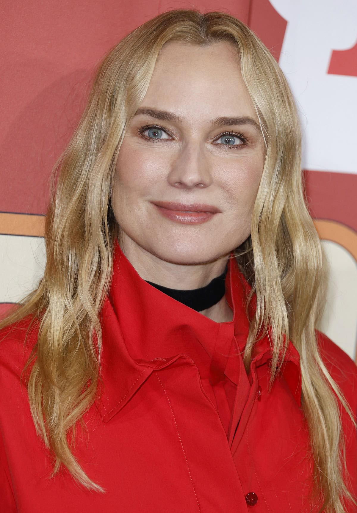 Diane Kruger styles her festive ensemble with a thick black choker and a red scarf tucked into the blouse's neckline