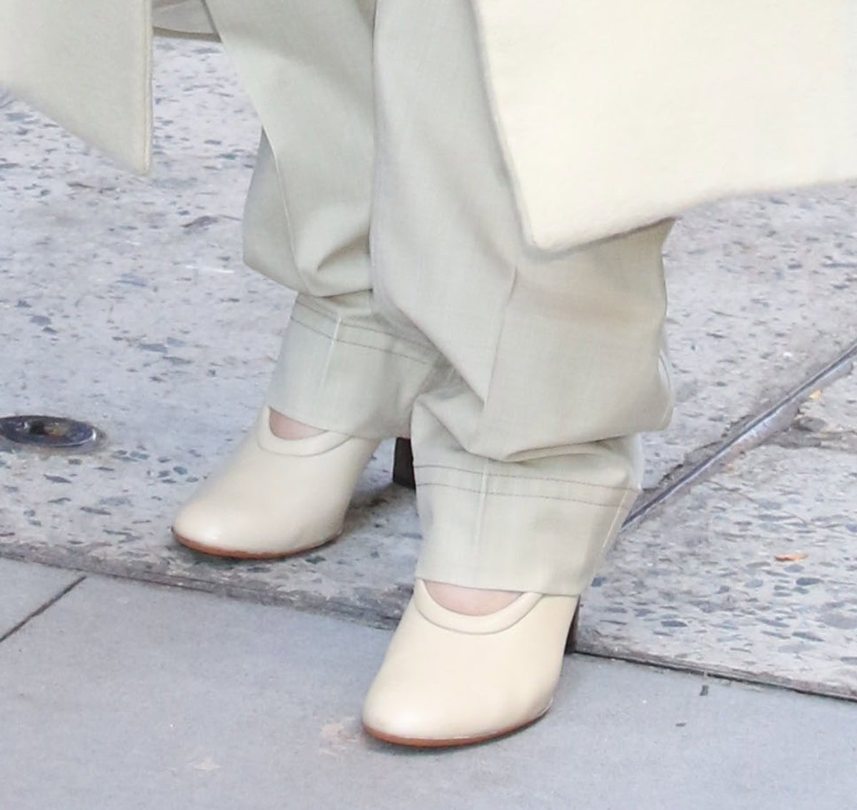 Elle Fanning teams her look with creamy Tod's "Decolette" pumps featuring a sculptural opening, elongated vamps, and wooden heels