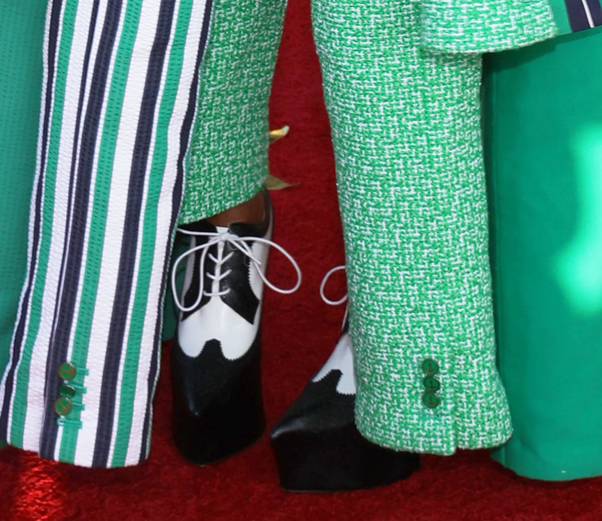 Janelle Monáe pairs her chaotic green Thom Browne suit with black-and-white platform oxfords, complete with white laces, pinked trims, and a wingtip