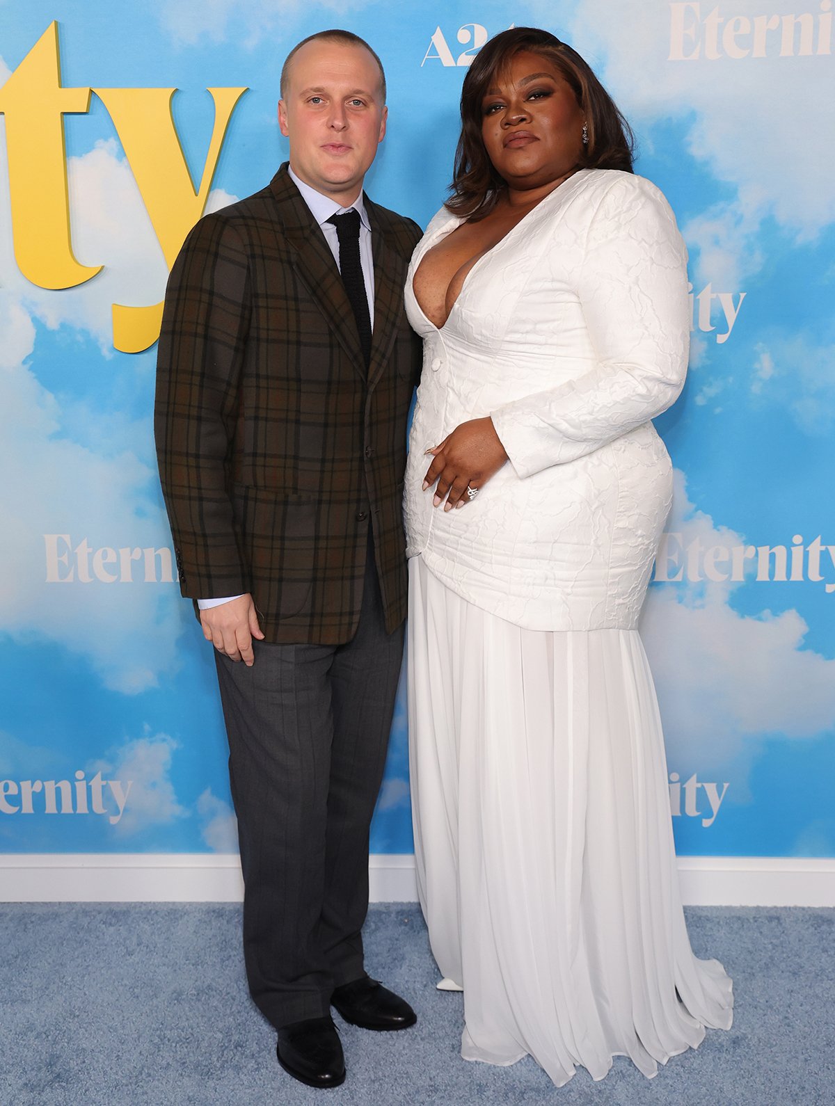 Da’Vine Joy Randolph, pictured with co-star John Early, channels modern bridal elegance in a custom white Laith Maalouf gown paired with coordinating white pointed-toe pumps
