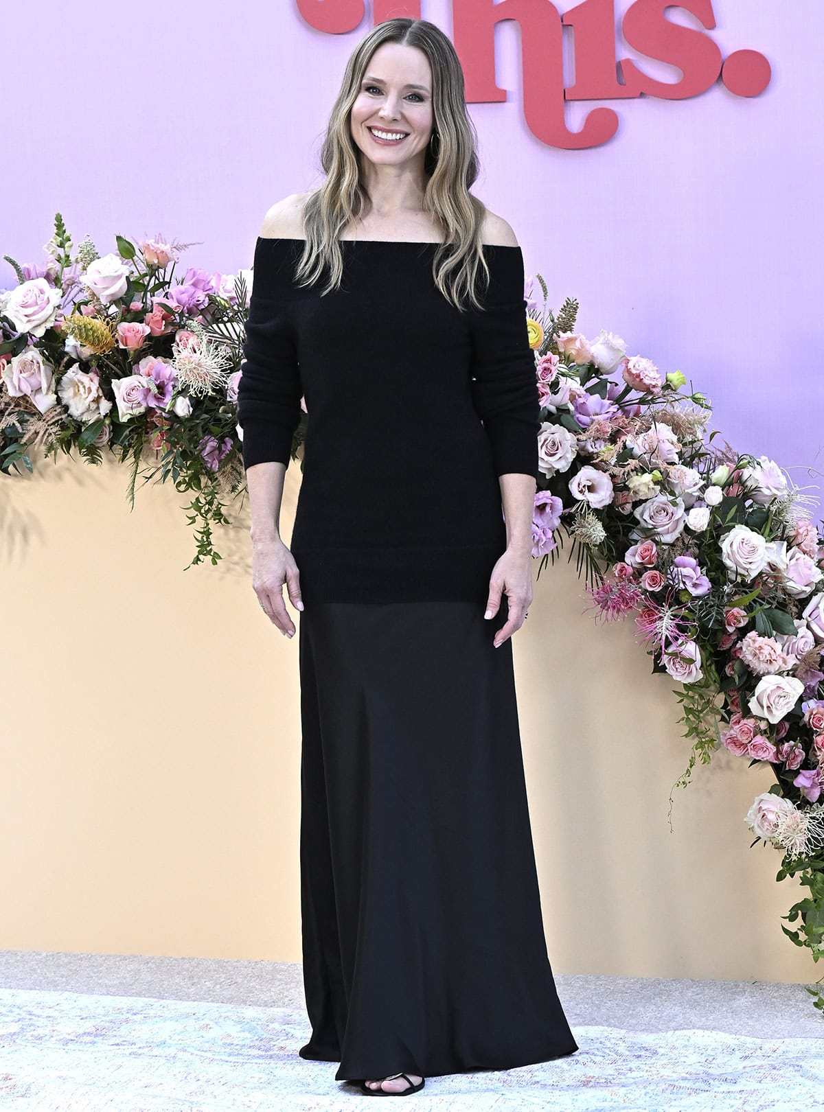 Kristen Bell goes the minimalist route, wearing a black off-the-shoulder dress with a cashmere–merino blend bodice and a silk skirt by Christopher Esber