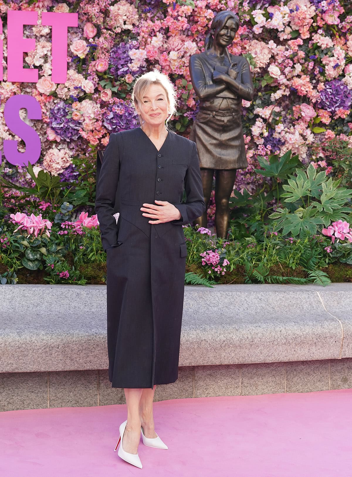 Renée Zellweger keeps her look sophisticated, pairing her white-and-red pumps with a black coat dress