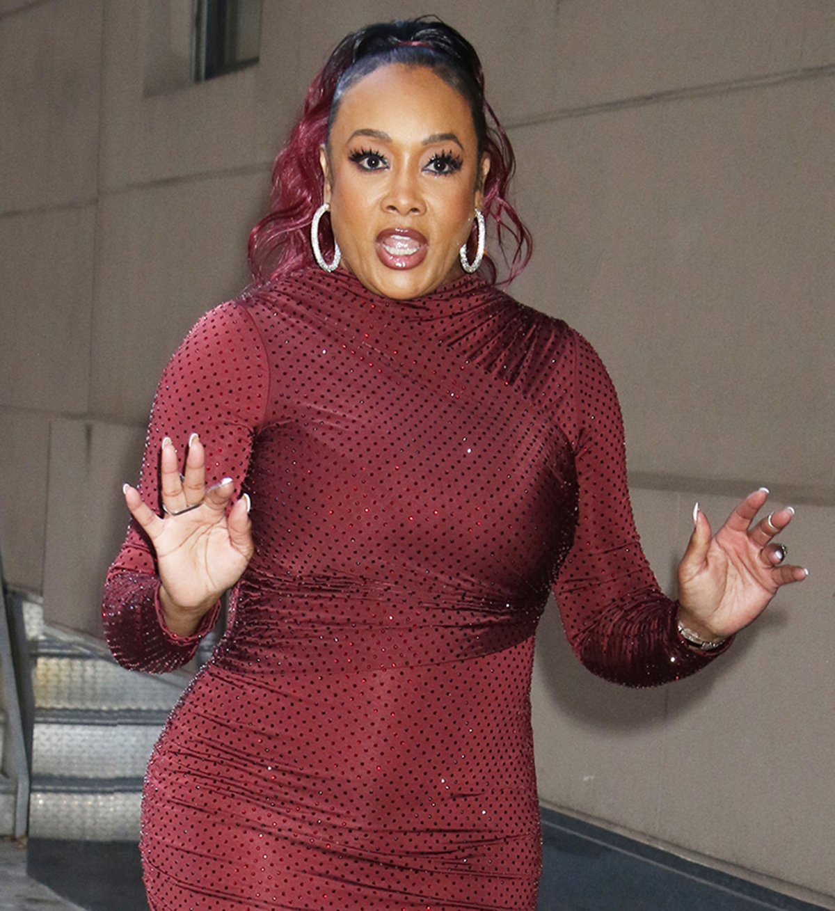 Vivica A. Fox enhances her look's sparkle with crystal hoop earrings and statement rings, and wears her red-dyed hair in a high ponytail