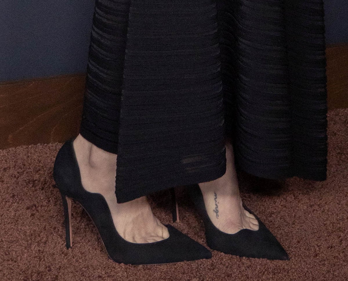 Amanda Seyfried teams her black dress with black Aquazzura “Artiste” pumps featuring undulating, scalloped uppers, pointed toes, and stiletto heels