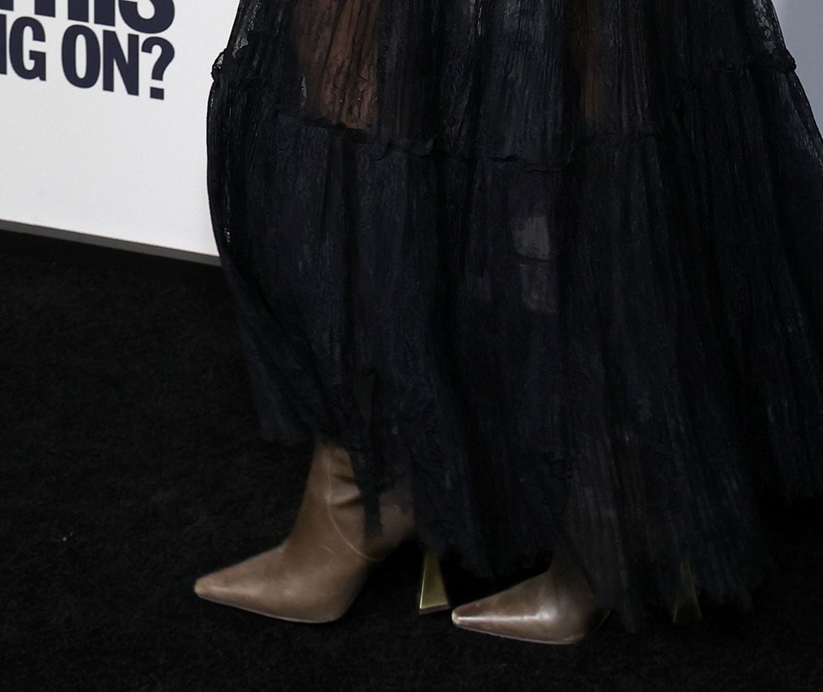 Andra Day adds contrast to her outfit's sheer drama with beige taupe knee-high boots featuring a squared pointed toe and metal flared heels