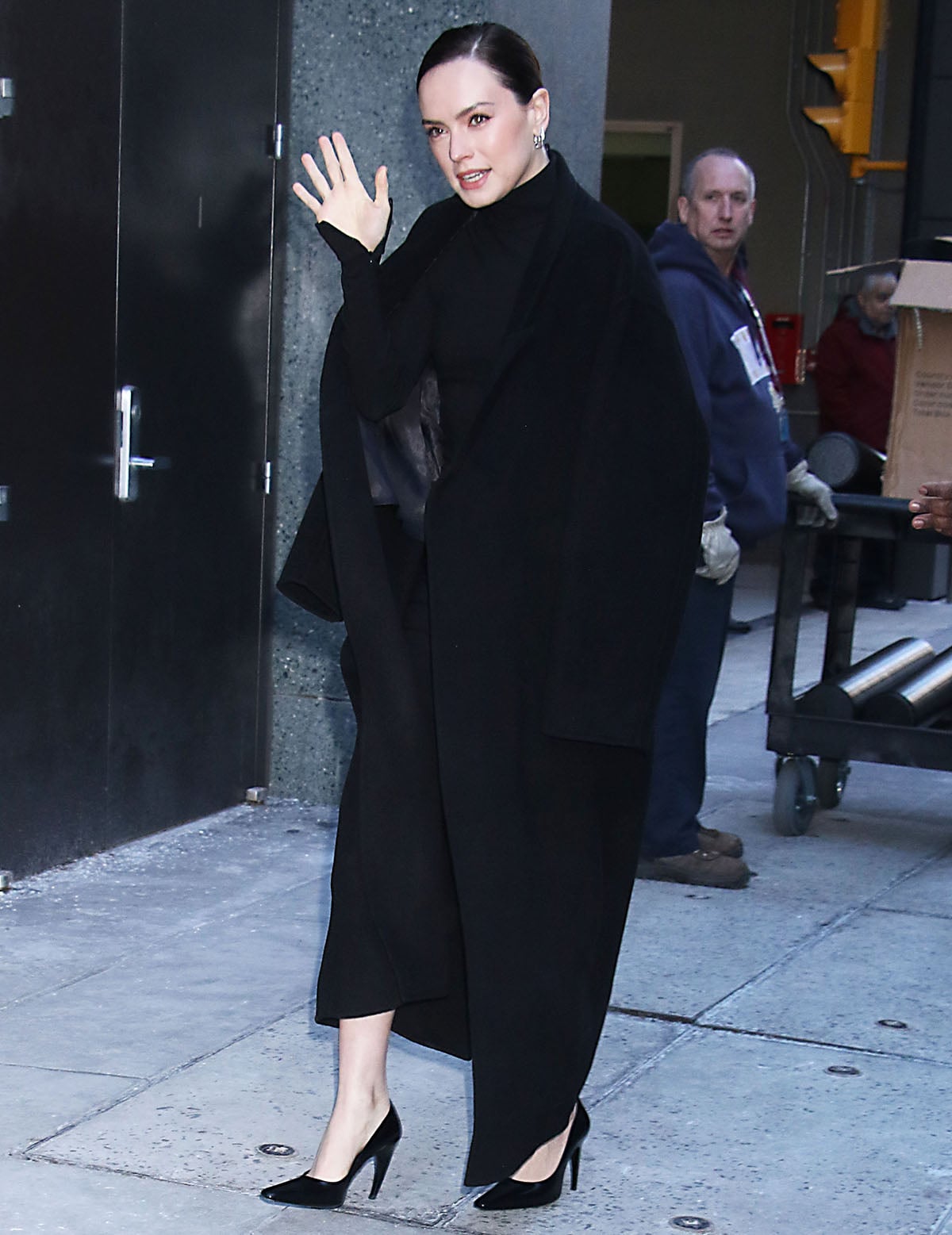 Daisy Ridley pairs her Jude pumps with a gorgeous black dress featuring an asymmetrical hem, turtleneck, and long sleeves