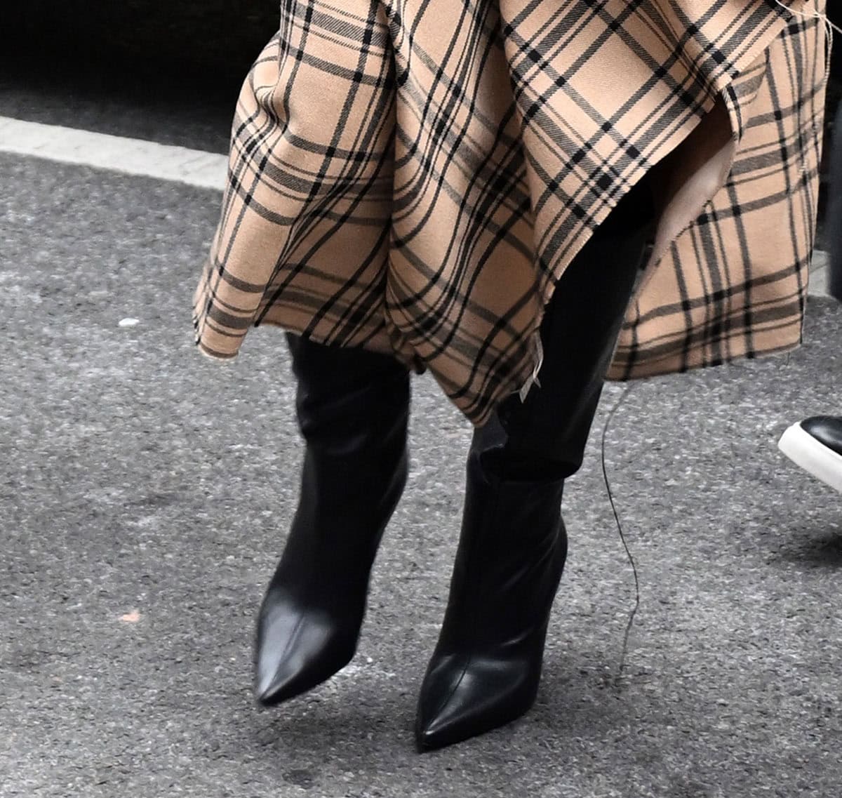 Kate Hudson completes her winter-chic skirt suit with black pointed-toe knee-high boots, giving her outfit a hint of modern edge