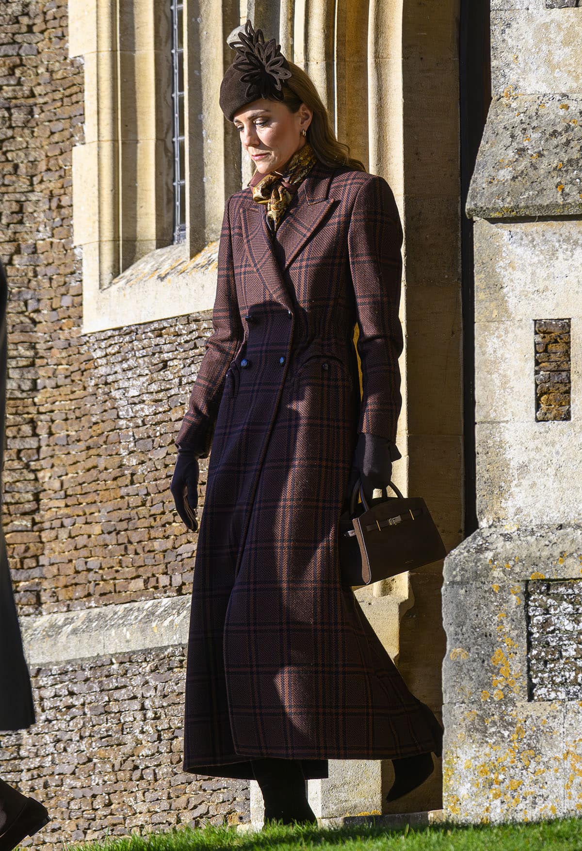 Kate Middleton embraces a polished holiday look in a brown windowpane check double-breasted coat by Blaze Milano with a Gucci pleated check wool-twill midi skirt underneath
