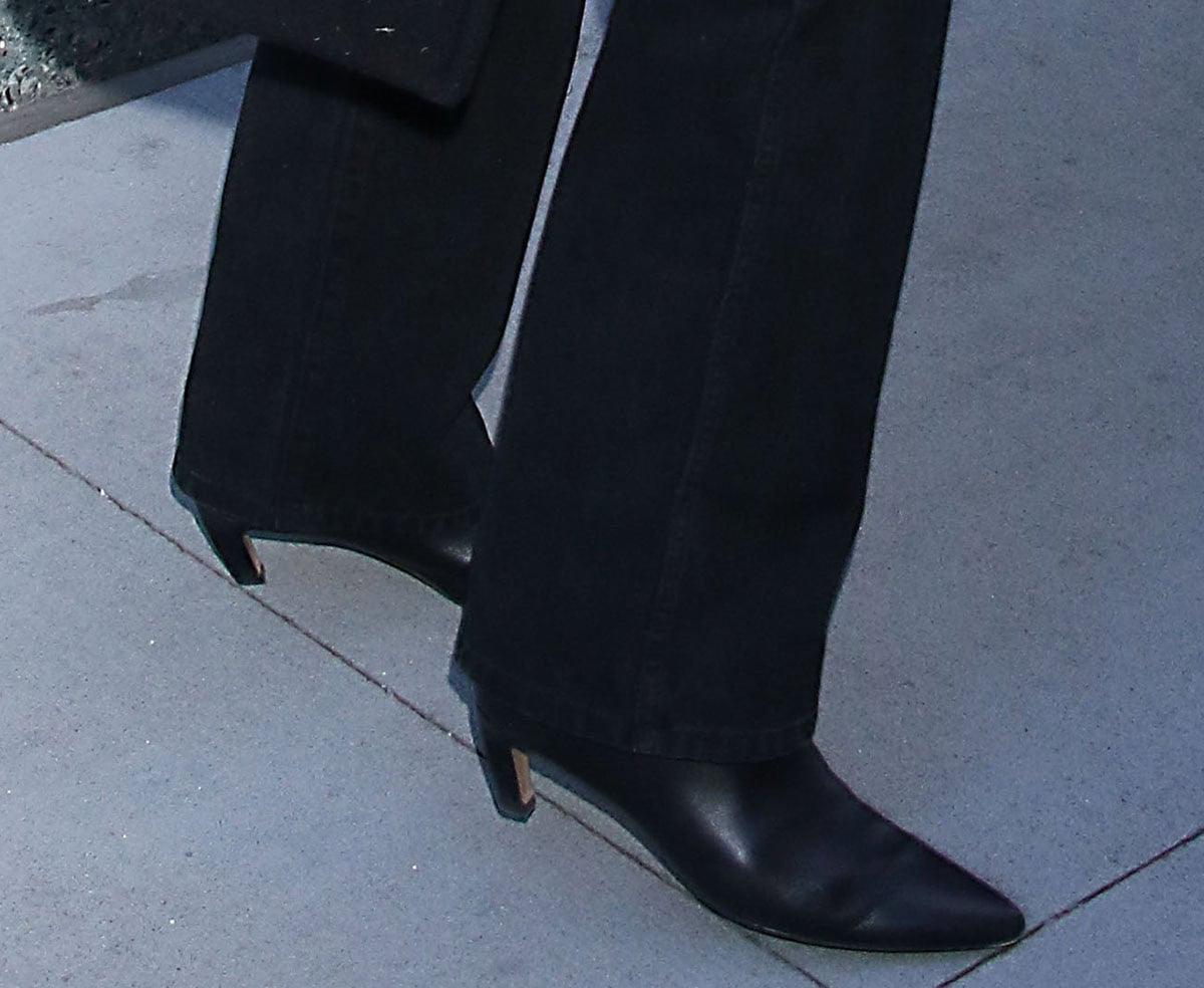 Laura Dern finishes her casual press-day look with sleek black pointed-toe boots, defined by short comma heels that add subtle lift while keeping the silhouette streamlined and practical