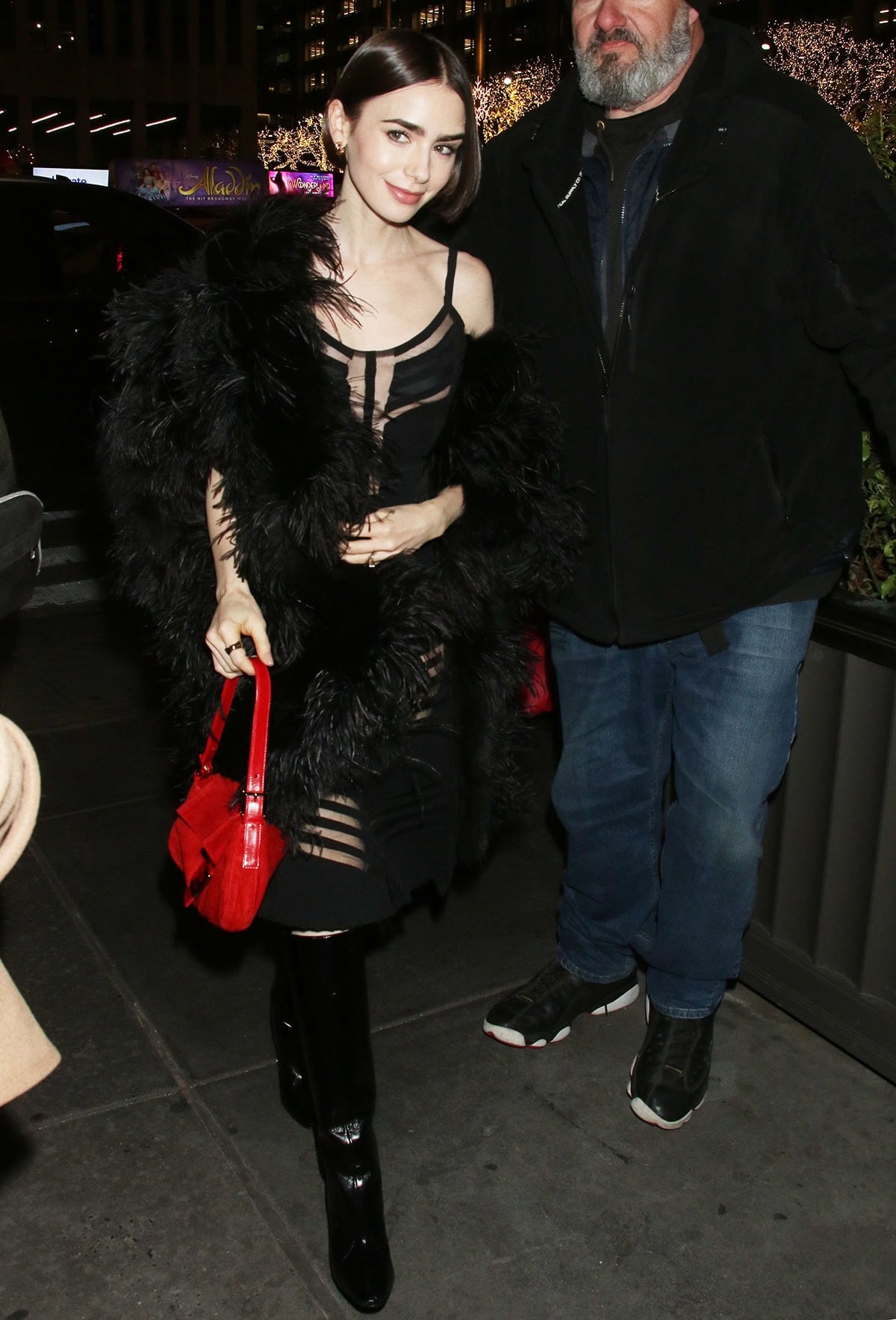 Lily Collins is seen in Midtown Manhattan on December 9, 2025, stepping out near the Jimmy Fallon studios in a sheer black Fendi dress from the Fall 1997 collection