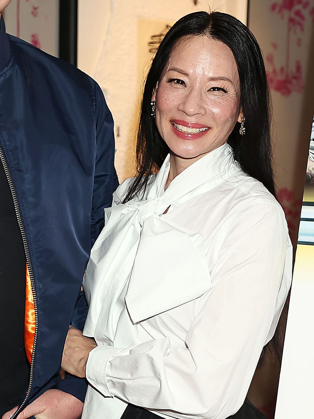 Lucy Liu keeps her styling and beauty look simple, wearing her hair straight and highlighting her natural beauty with soft pink makeup