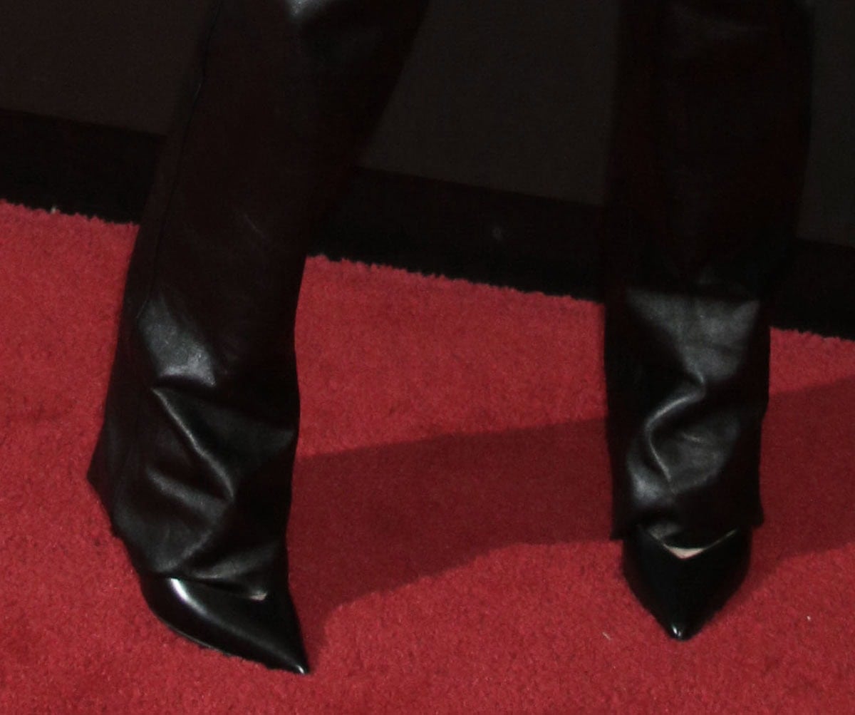 Natalia Dyer sharpens her tough-chic leather look with sleek black pointed-toe pumps, adding polish to the outfit’s edgy silhouette