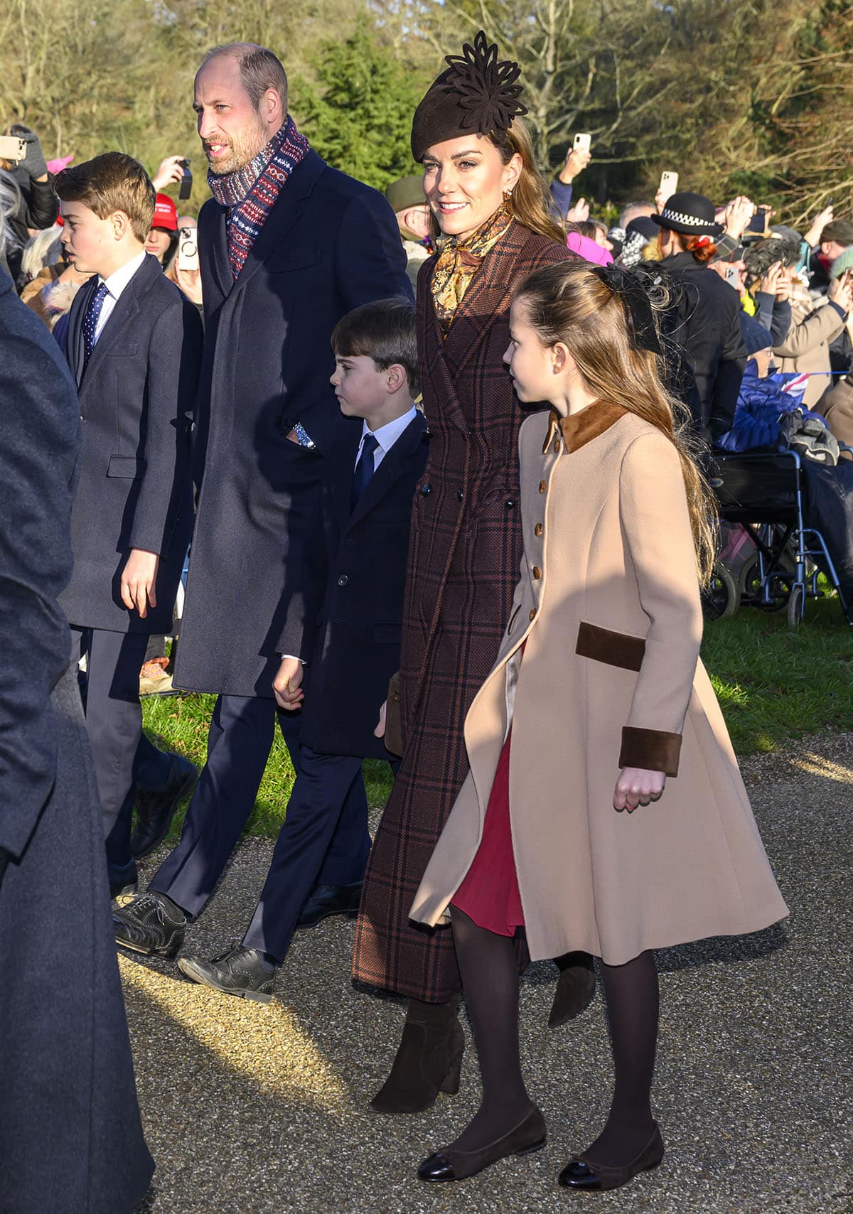 Prince William coordinates with Prince George and Prince Louis in tailored navy suits, grounding the family’s Christmas look with timeless black oxford shoes