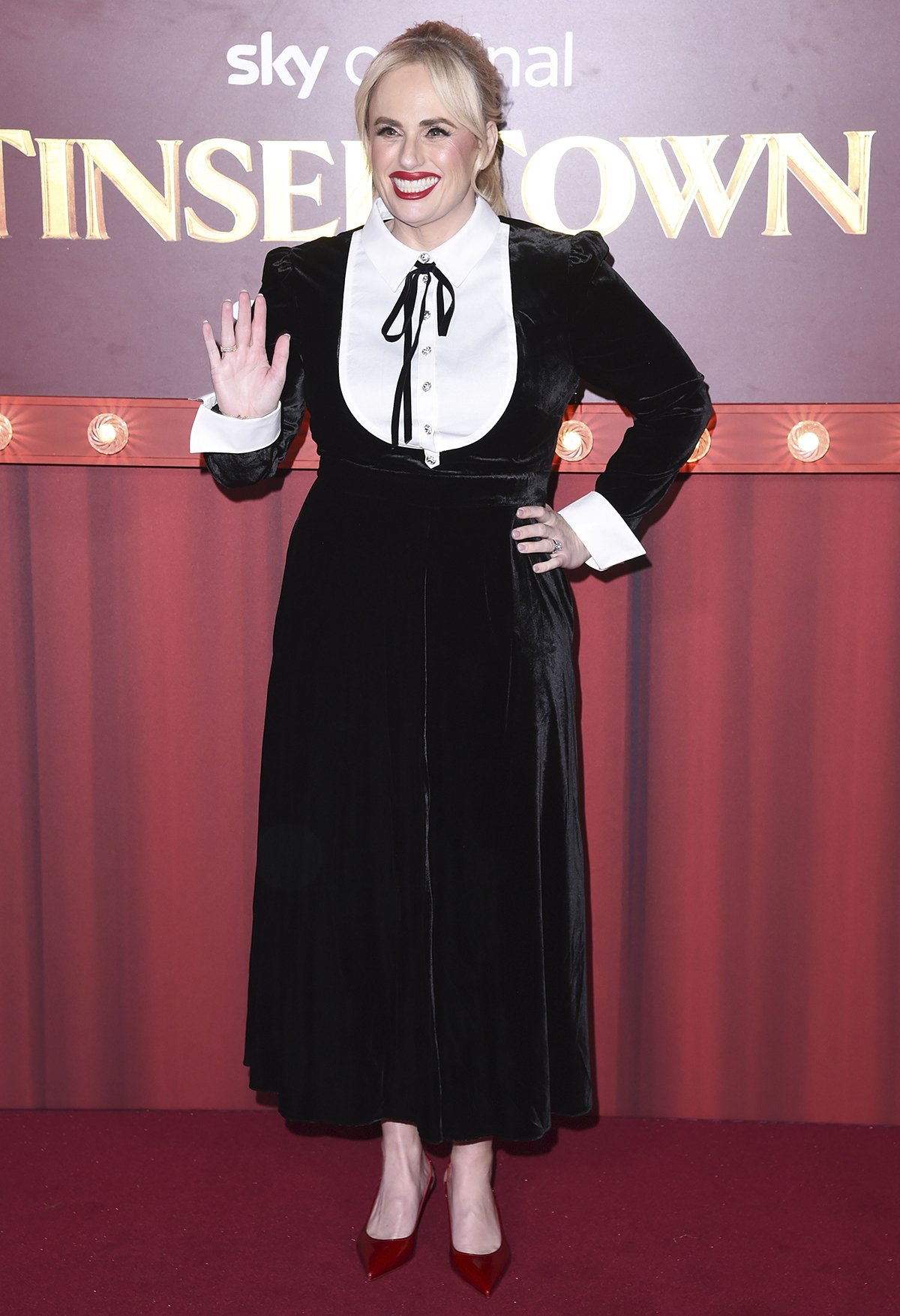 Rebel Wilson brings vintage charm to the Tinsel Town world premiere on November 27, 2025, in a black velvet Temperley London dress paired with glossy red Christian Louboutin slingback pumps