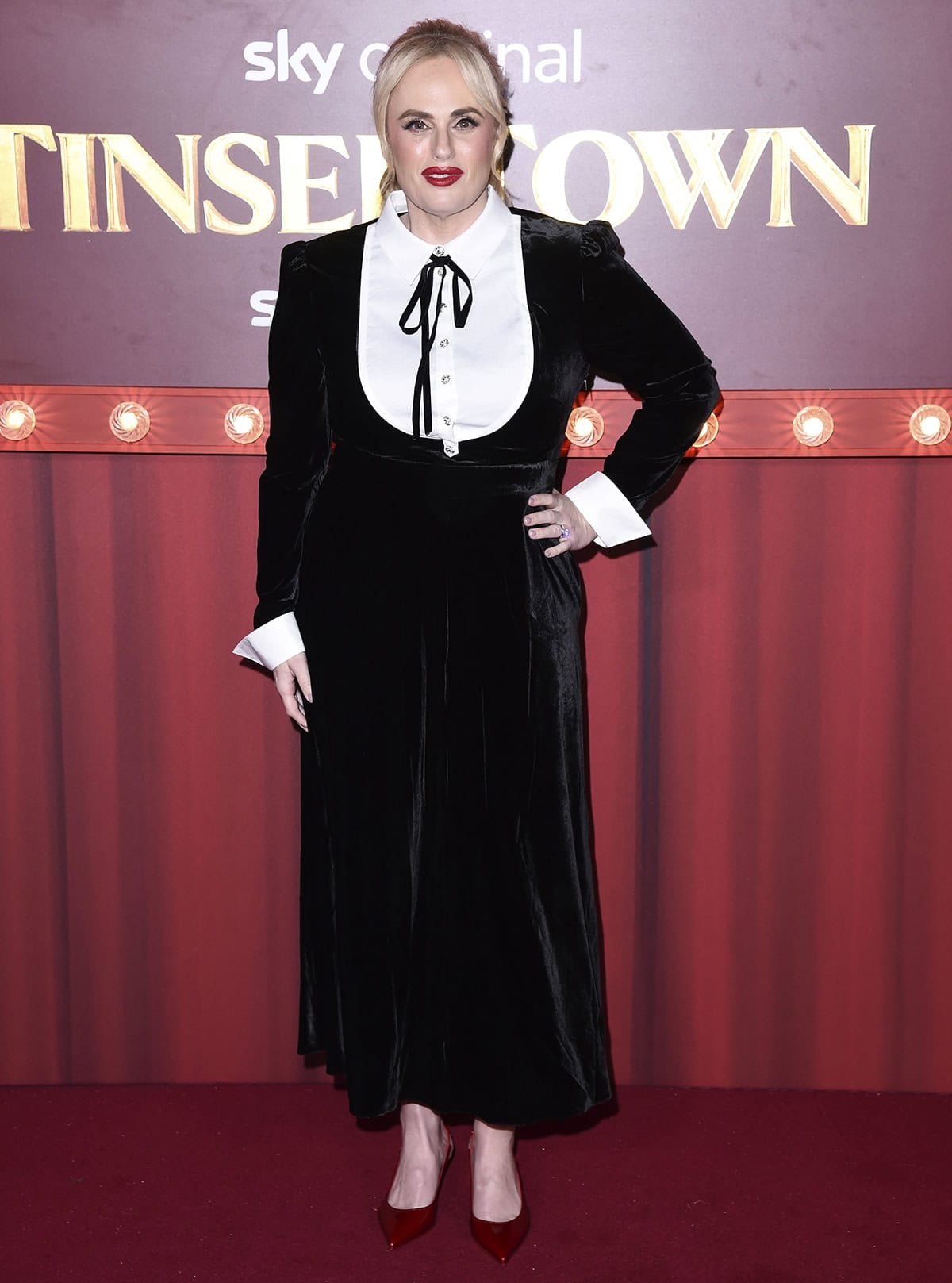 Rebel Wilson embraces vintage elegance in a black velvet Temperley London dress with a white bib, accented with crystal buttons and a thin black tie