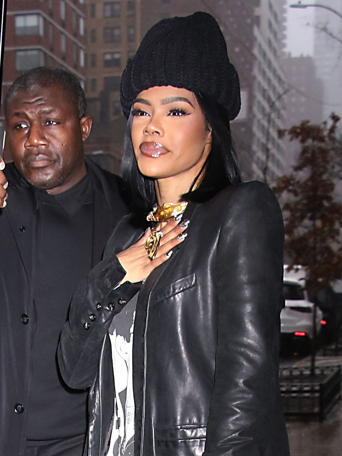 eyana Taylor goes bold with accessories, styling her edgy leather look with gold Schiaparelli jewelry, a beanie, and a full face of makeup