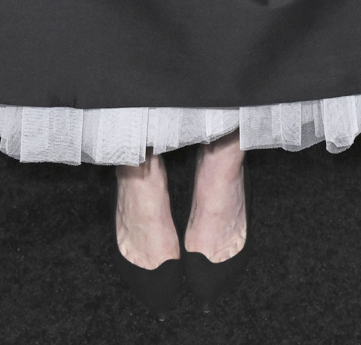 Amanda Seyfried pairs her sculptural dress with black suede Aquazzura “Artiste” pumps featuring a scalloped topline, pointed toes, and high heels