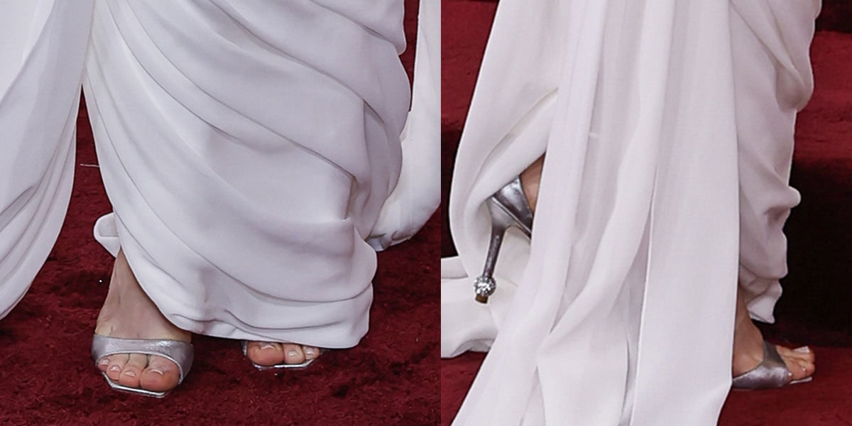 Amanda Seyfried wears the metallic silver Roger Vivier “Marlene” sandals featuring an insole with a red heart motif, a crystal buckle, and a crystal bouclé at the heel