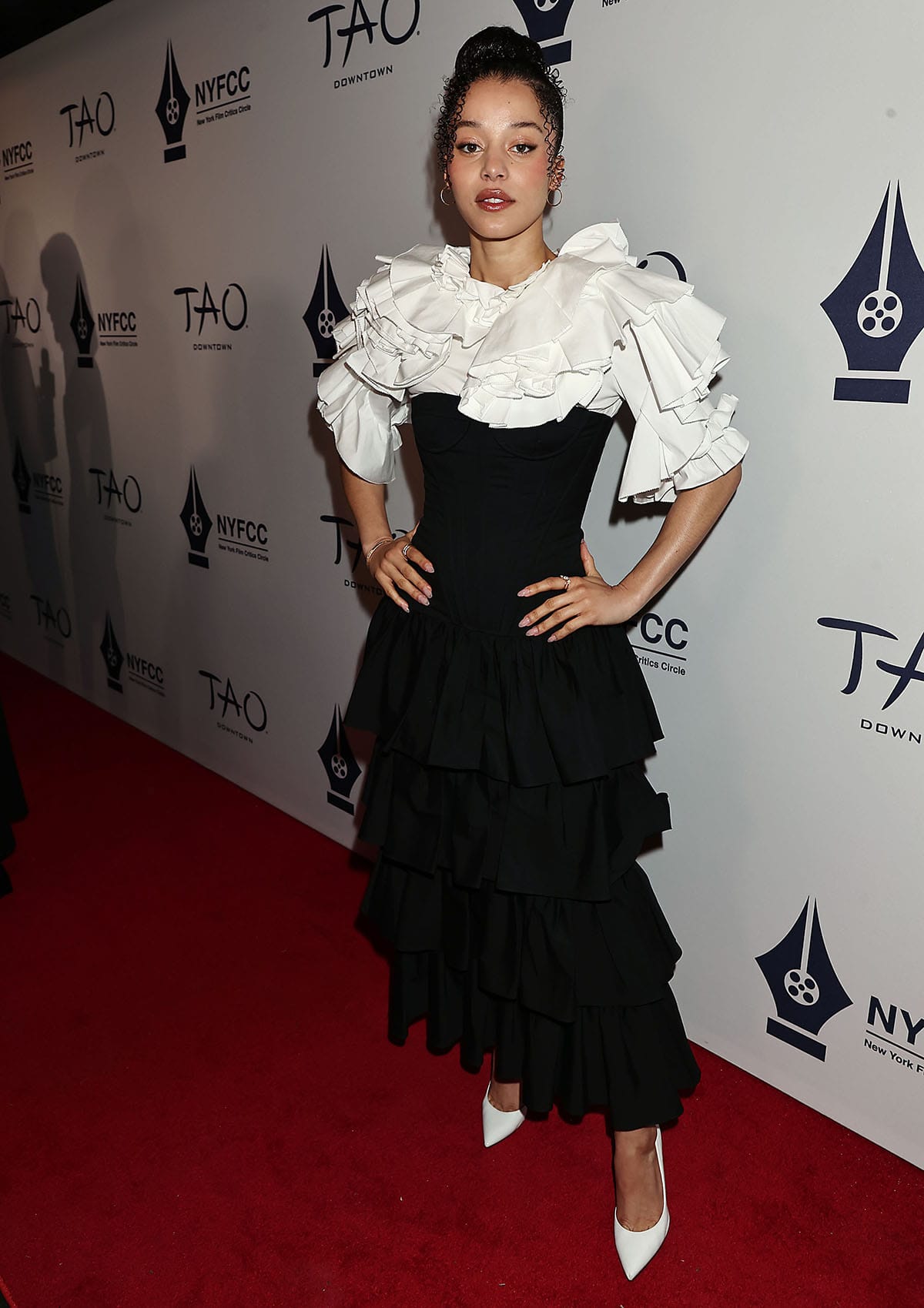 Chase Infiniti opts for the dramatic black-and-white Carolina Herrera dress featuring a corseted black bodice, a tiered ruffled skirt, and an oversized white ruffled top