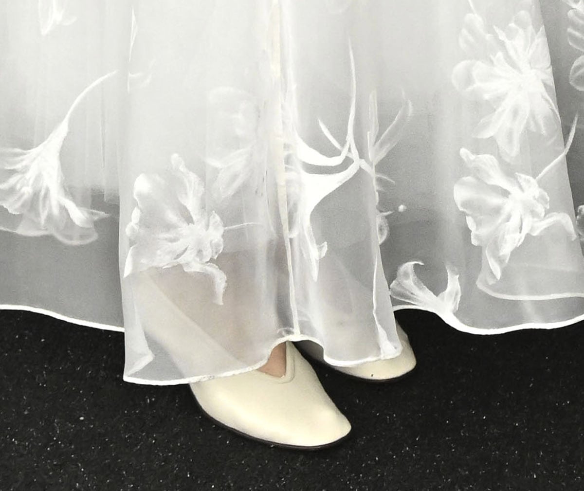 Chloé Zhao finished her bridal-inspired ensemble with sleek off-white glove pumps, a minimalist choice that underscored the look’s soft romance and modern restraint