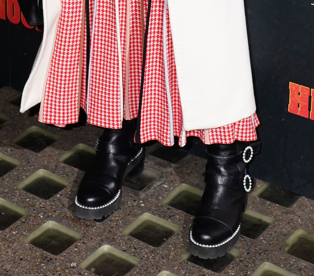 Dame Helen Mirren looks cool wearing a pair of Russell & Bromley “Pearlqueen” biker boots featuring round pearl buckles and pearl trims