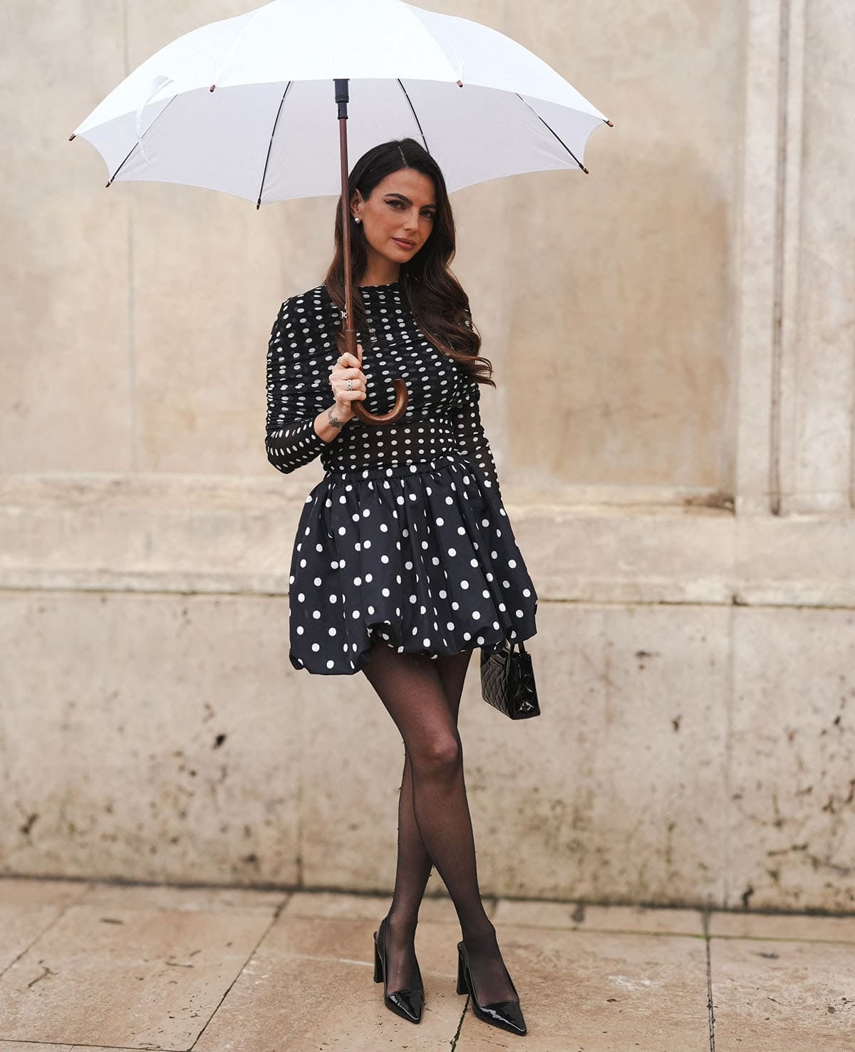 Kelly Piquet teams her shoes with a polka-dot set featuring a long-sleeved top with ruched detailing around the shoulders and a bubble mini skirt
