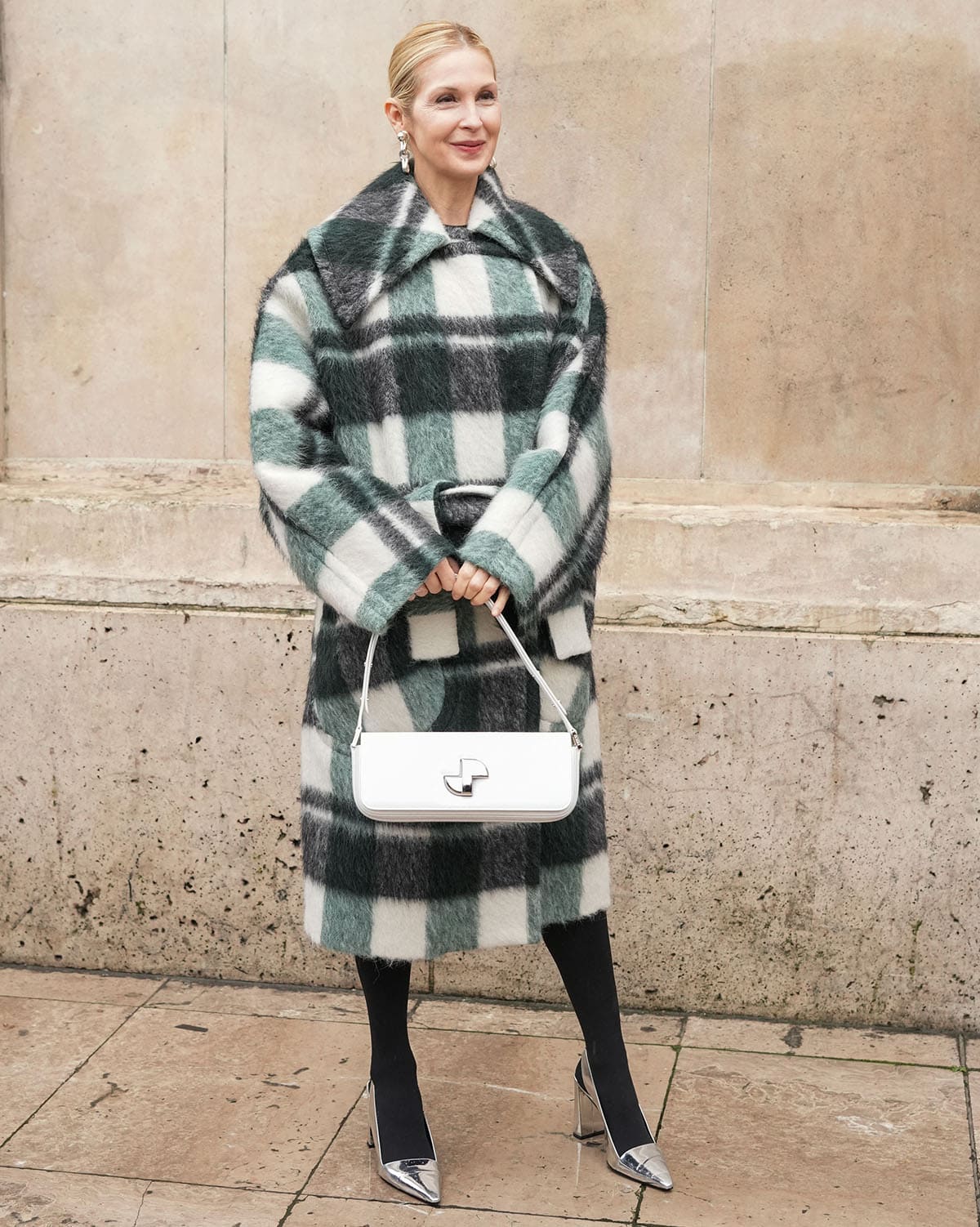 Kelly Rutherford looks cozy, pairing her silver pumps with black tights and a green-black-white coat with a boxy collar