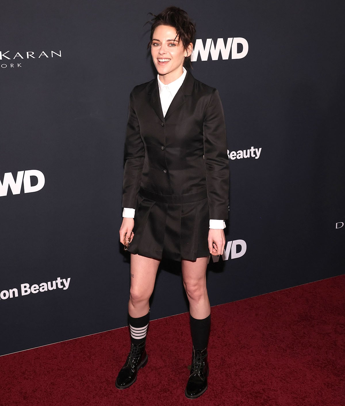 Kristen Stewart looks sharp and edgy in a black Thom Browne sportcoat, pleated mini dress, with a crisp white shirt underneath