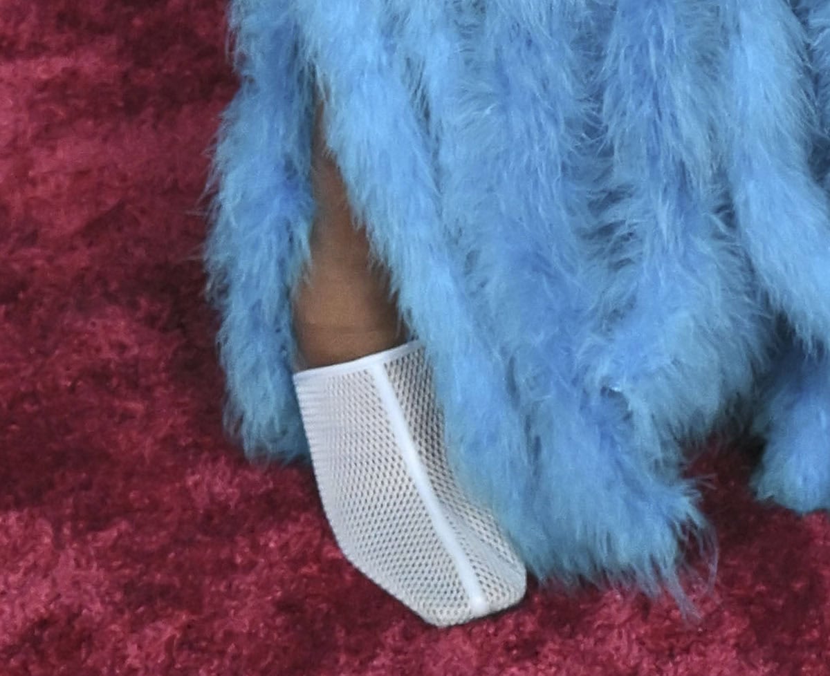 Shola Adewusi slips into a pair of airy white mesh mules with square toes and high vamps