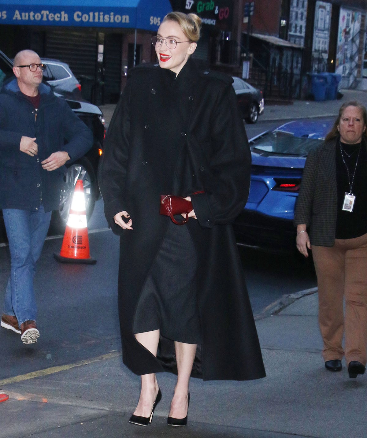 Sophie Turner is the epitome of an office siren in a black Self Portrait Blazer midi dress and a black Khaite coat