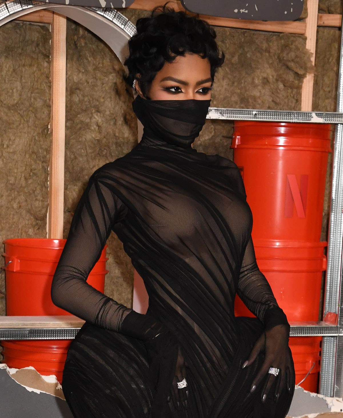 Teyana Taylor looks fierce with her smoky eyeliner and curly hair, and accessorizes her sheer black look with a diamond ear cuff and statement diamond rings by Repossi and Spinelli Kilcollin