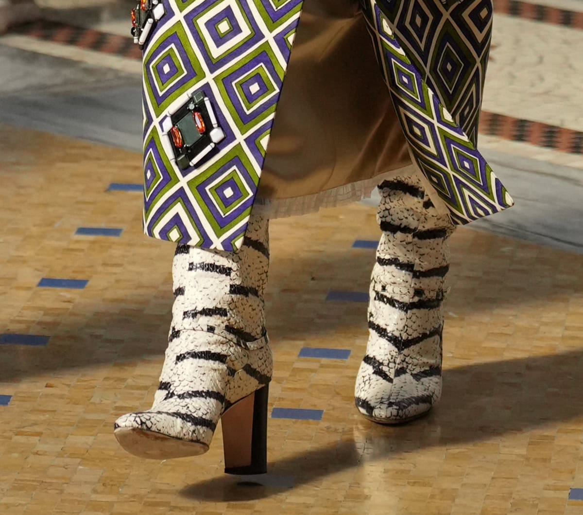 Anna Wintour slips into a pair of white snakeskin boots with black stripes and thick wooden block heels